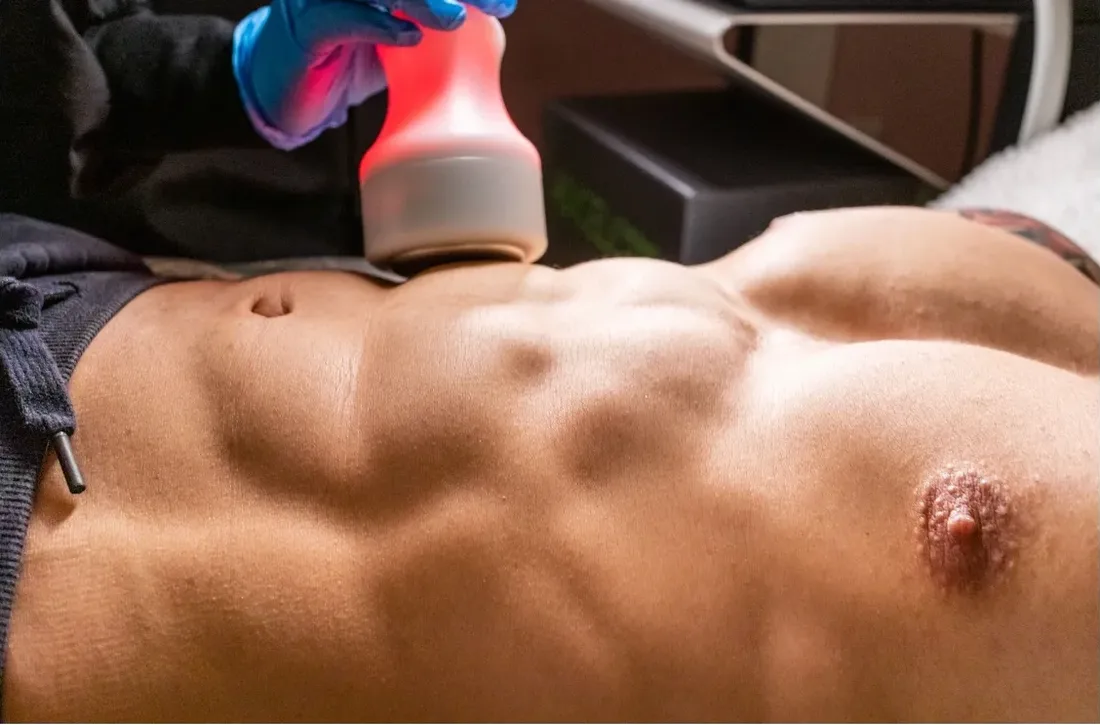 Treatment applicator held above a client's abdomen