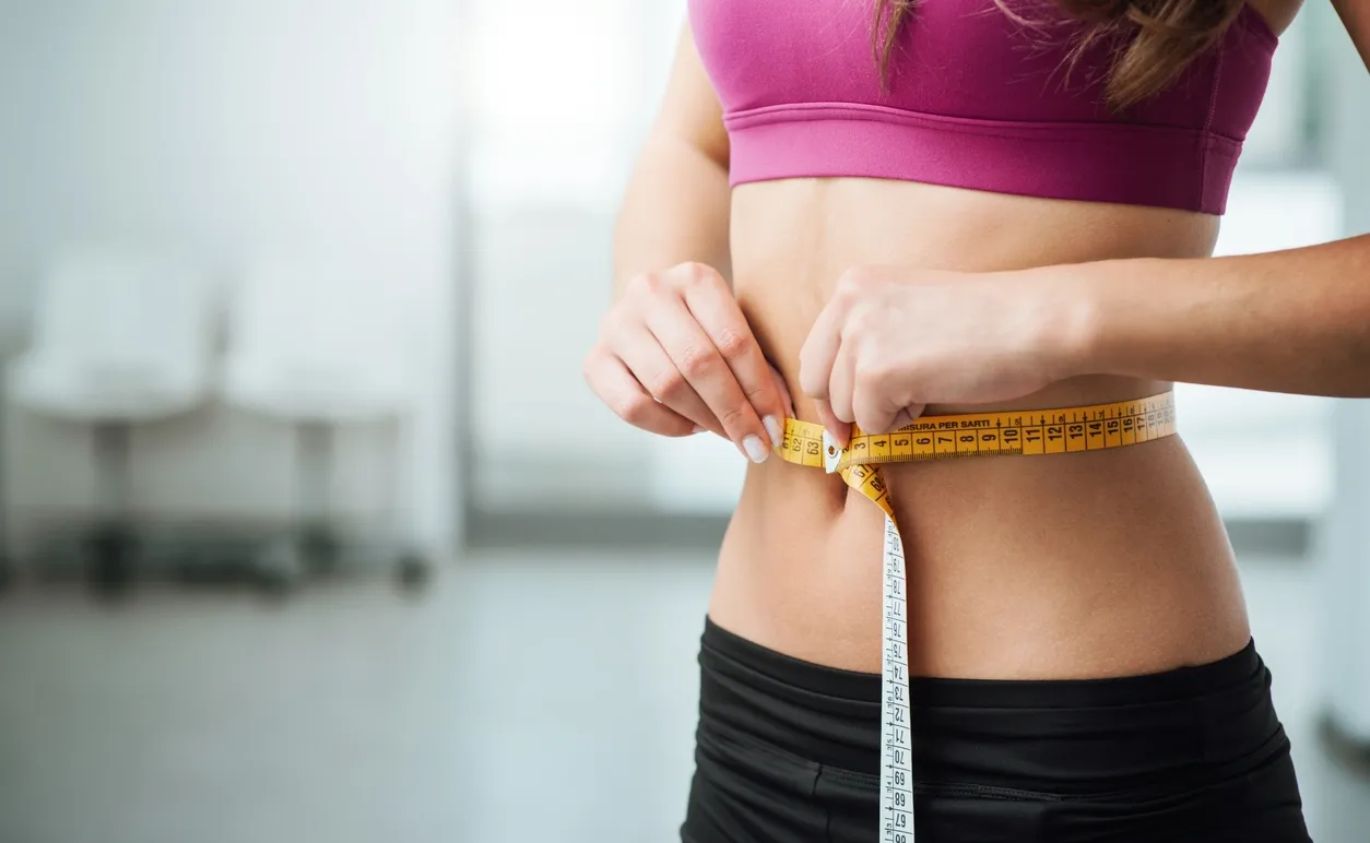 Person using a measuring tape at the waist